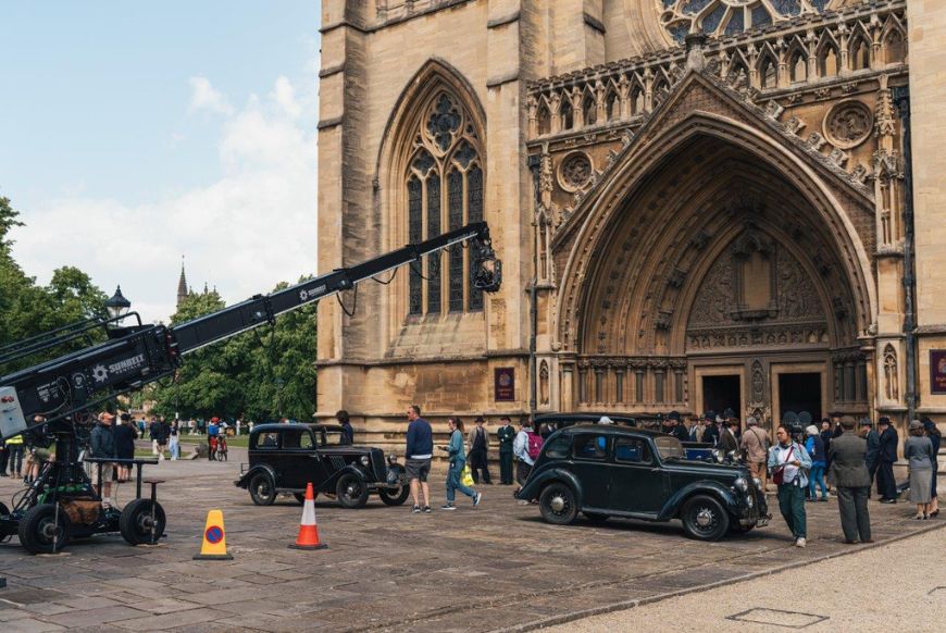 A camera crew filming in front of bristol cathedral